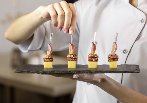 front-view-chef-holding-delcious-food-plate